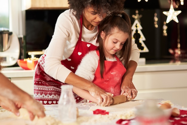 Free photo girl making cookies with mom